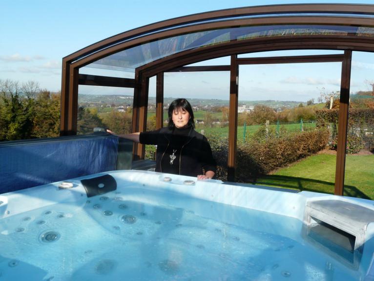 Je profite de mon spa de nage grâce à mon abri CARAT coulissant JURALU