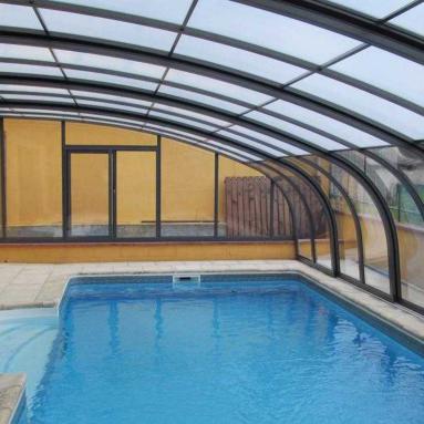 Abri de piscine adossé de type véranda rétractable I version cintrée coulissante I Modèle d'abri haut adossé mobile JURALU
